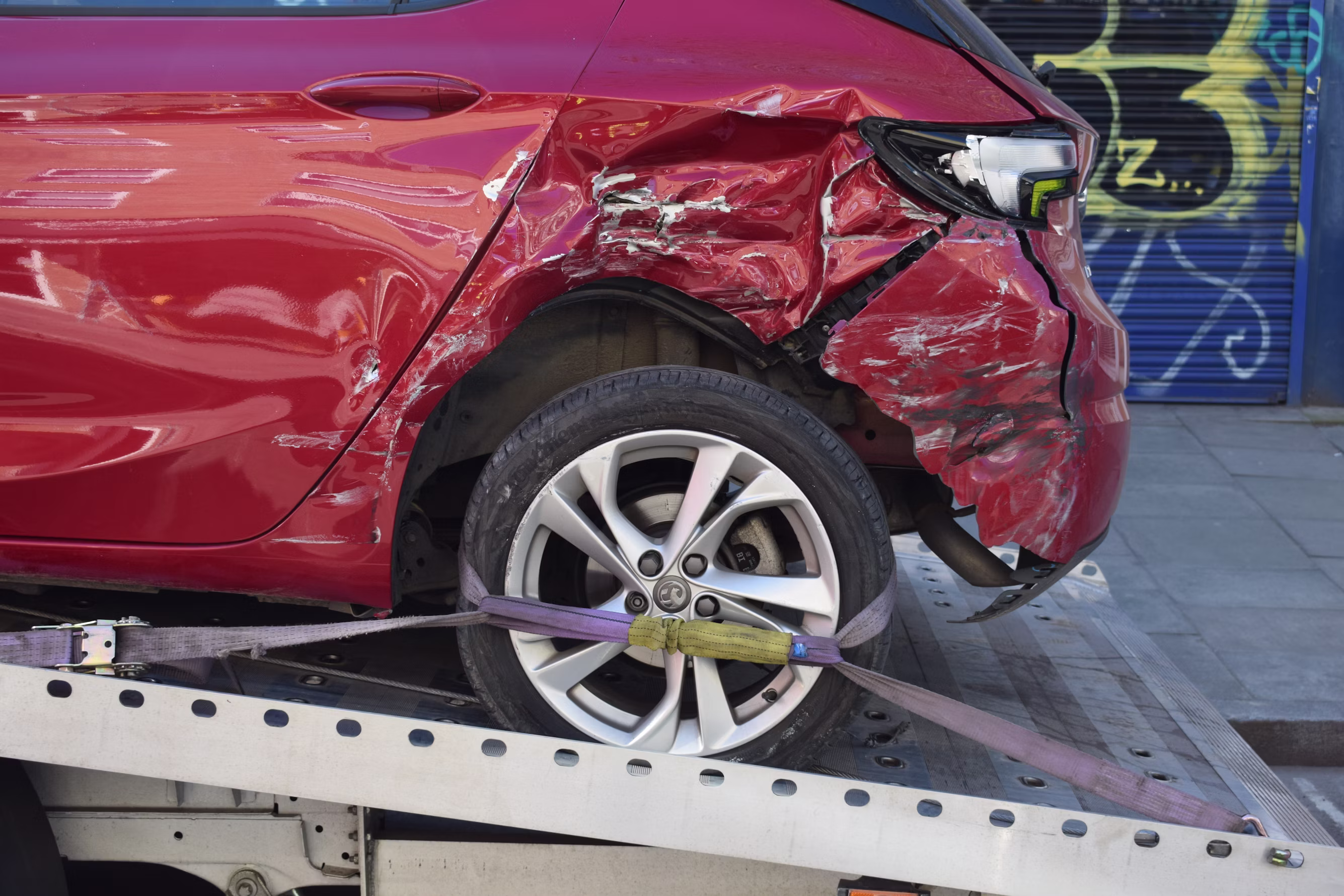 A car loaded on a Mizell's flatbed tow truck at night